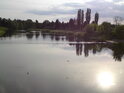 Říční práh na Orlici ve Svinarech. Klidná hladina odráží Slunce.